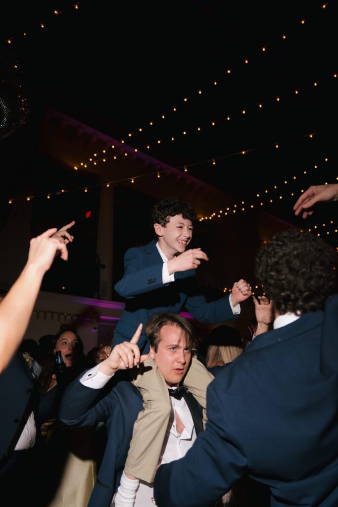 Guests dancing and celebrating on crowded dance floor Lightner Museum wedding St Augustine Florida