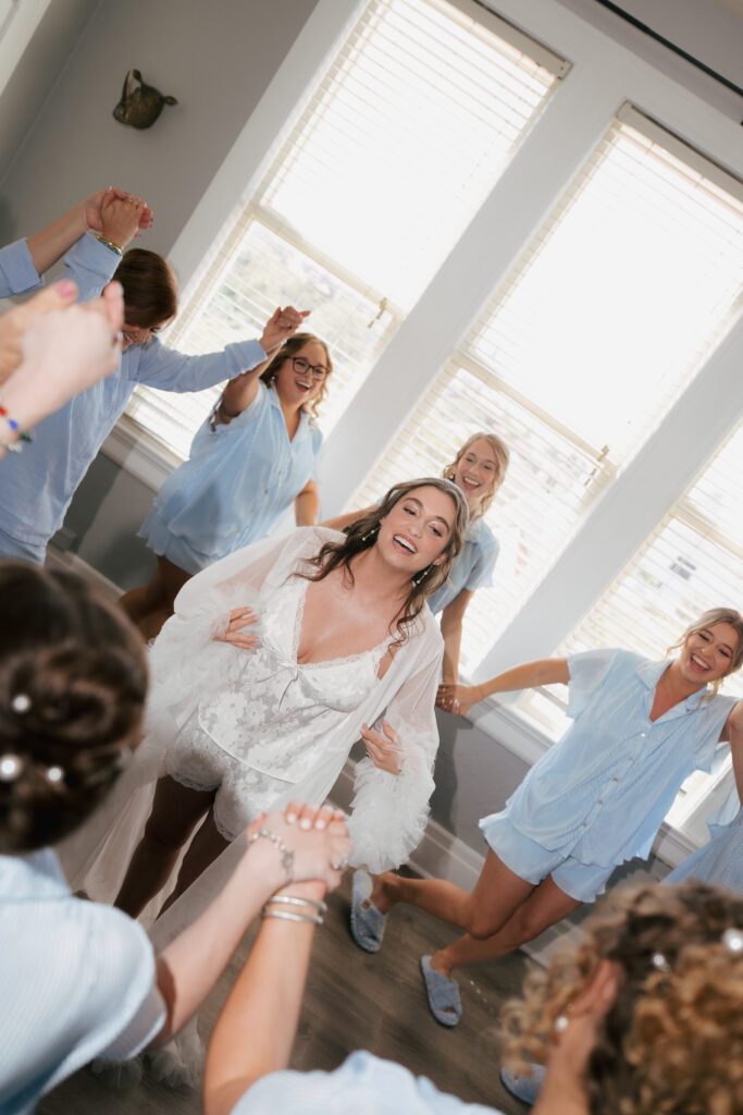 Bride and bridesmaids dancing getting ready in matching blue pajamas St Augustine Florida wedding morning