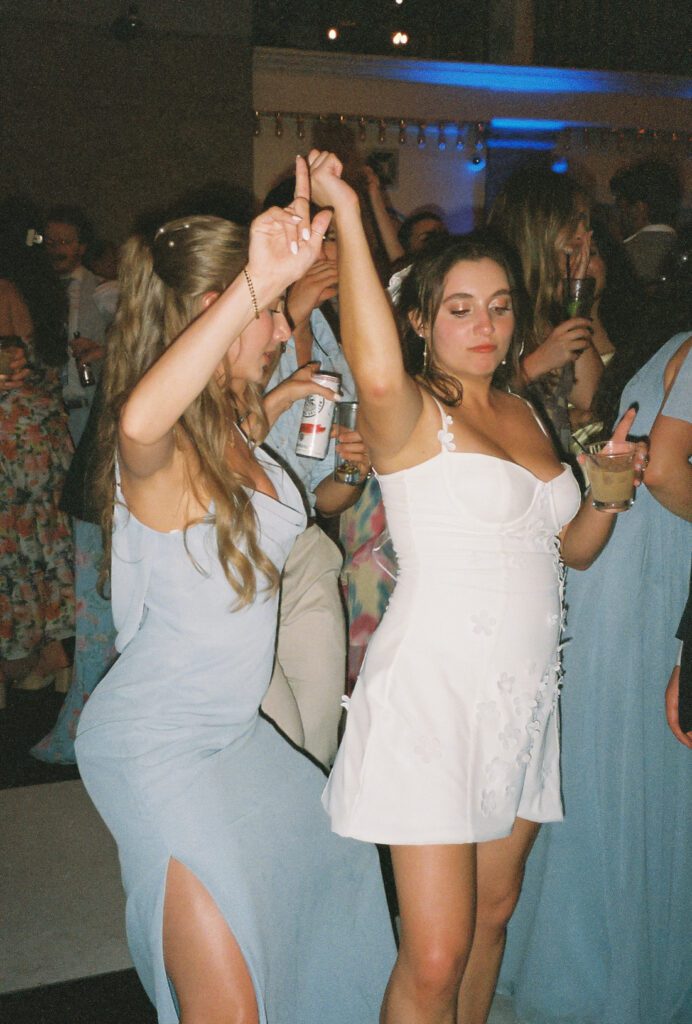 Bride dancing with bridesmaid on packed dance floor St Augustine Florida wedding reception