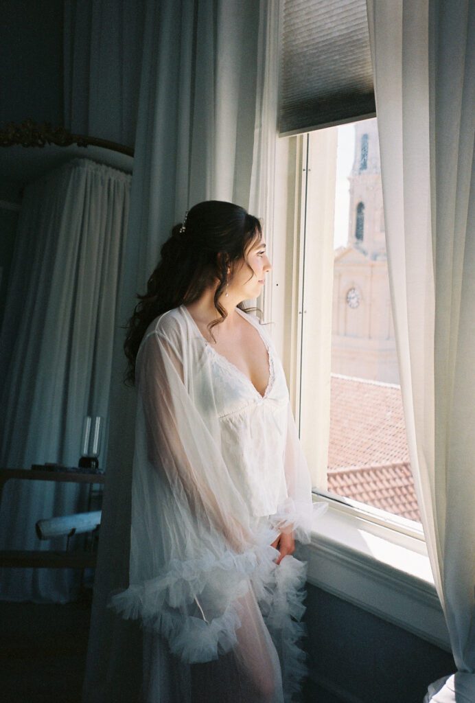 Bride getting ready by window in St Augustine Florida before Lightner Museum wedding