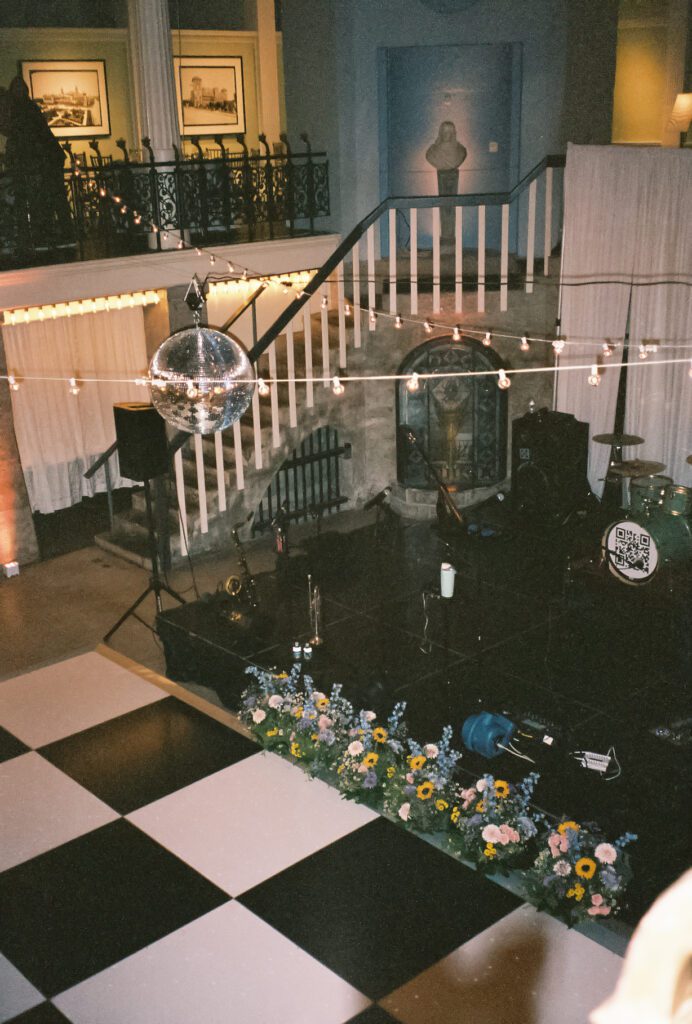 Lightner Museum reception stage with disco ball and live band setup St Augustine Florida wedding