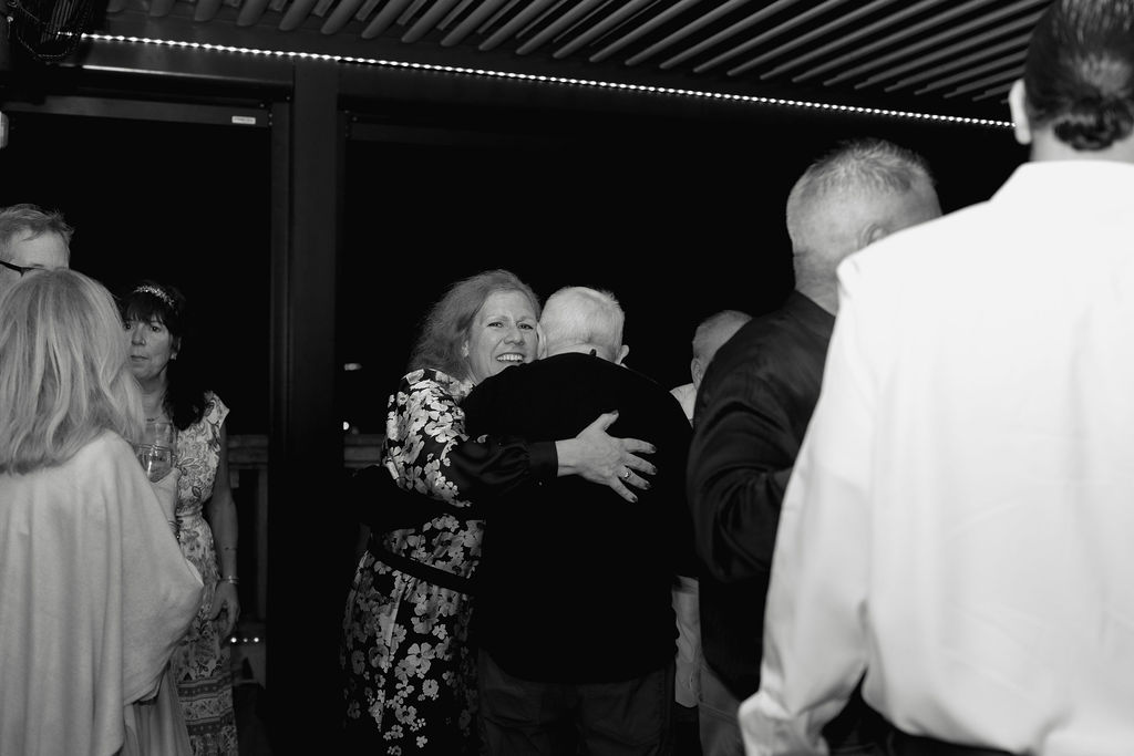 St Augustine Florida wedding rehearsal dinner guests hugging at rooftop bar destination wedding weekend celebration