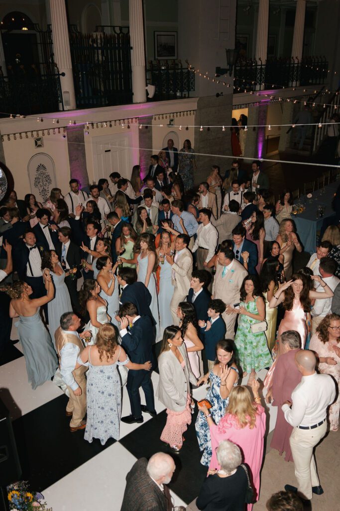 Guests dancing and celebrating on crowded dance floor Lightner Museum wedding St Augustine Florida
