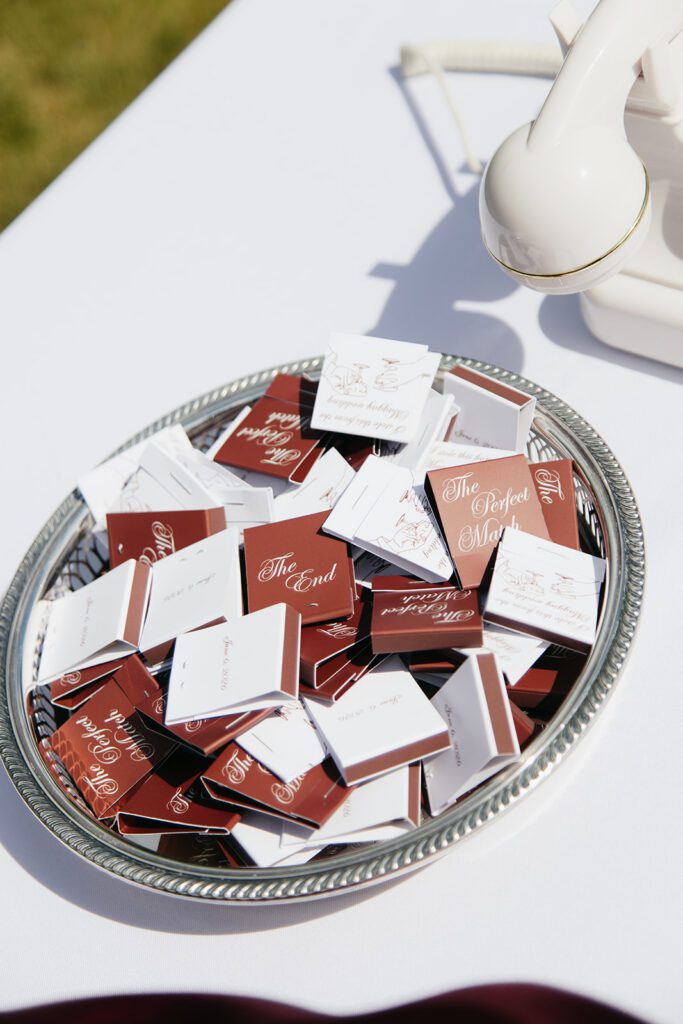 Silver tray of custom red matchbooks beside the audio guestbook telephone