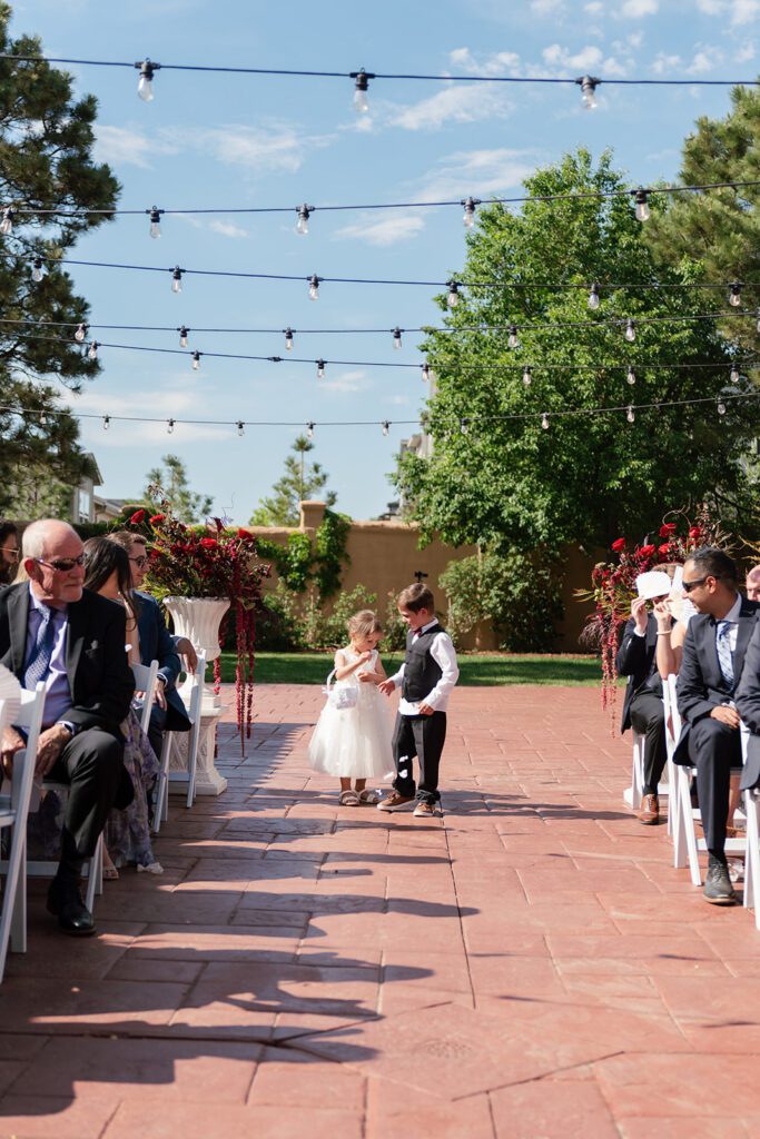 Flower girl and ring bearer walking the terracotta aisle at Villa Parker