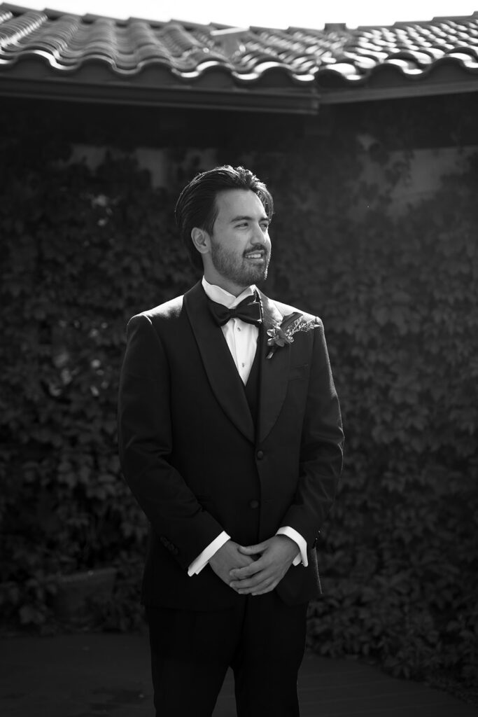 Groom waiting at the altar in front of an ivy wall at Villa Parker