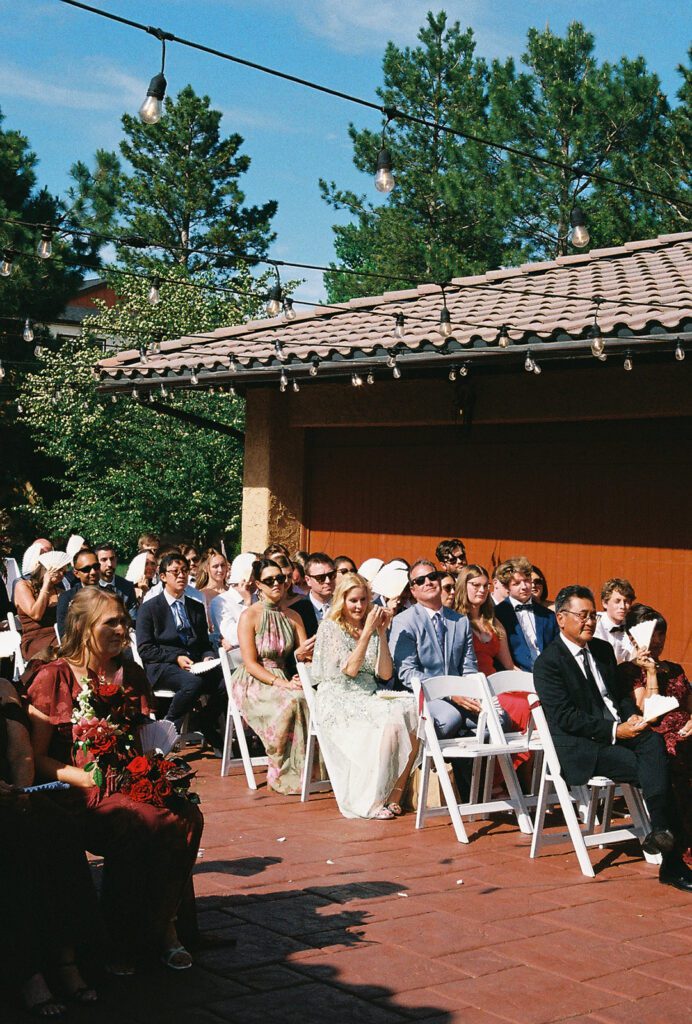 35mm photo of Guests seated under string lights for an outdoor courtyard ceremony at Villa Parker