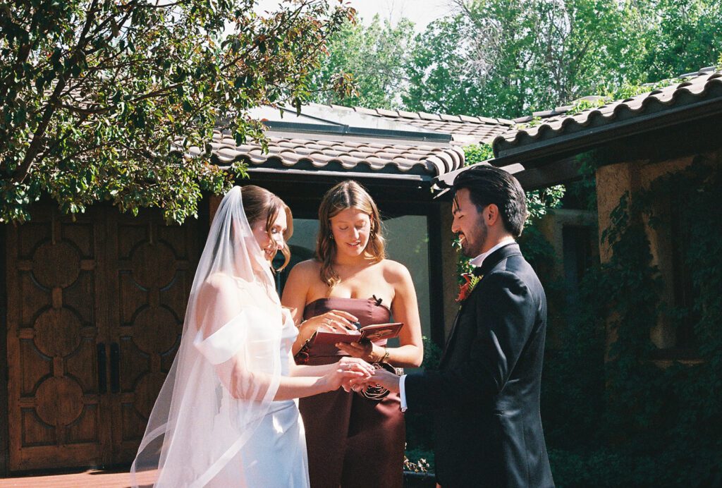 35mm film photo of Bride and groom exchanging rings at their villa parker ceremony